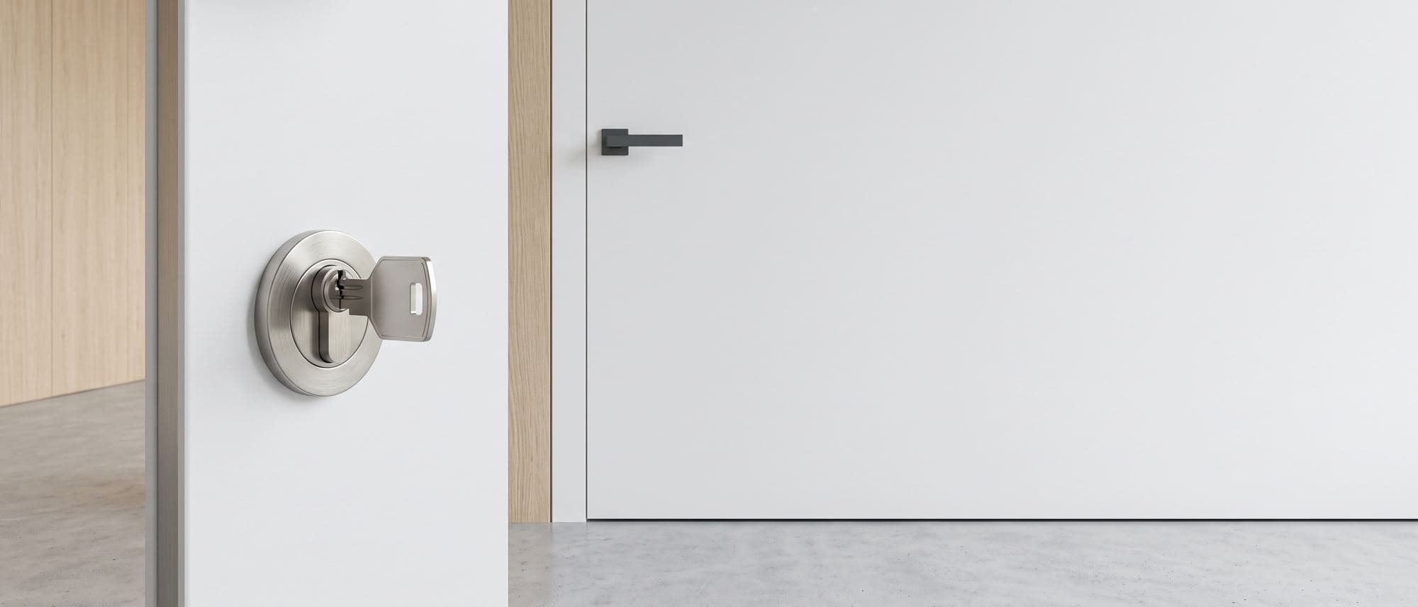 Cylindre en nickel brossé et sa clé plate sur une porte d’entrée blanche laquée fermée