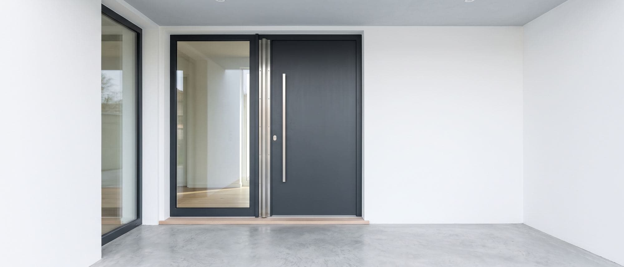 Porte d’entrée en aluminium anthracite fermée et intacte, dormant équipé d’une cornière et d’une gâche renforcée